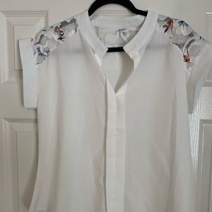 White blouse with rainbow colored bird pattern